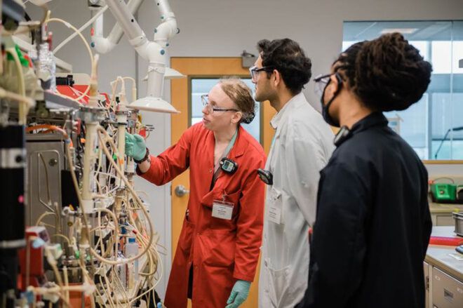 Scientists looking at a setup of wires