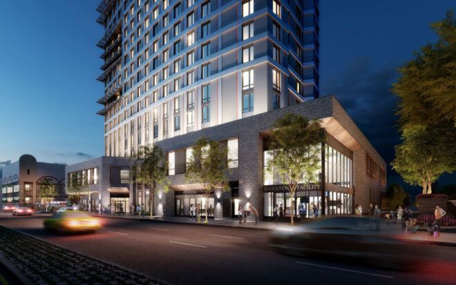Apartment building at night with a lobby lit up below