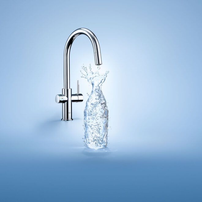 Water being poured from a faucet into a plastic water bottle