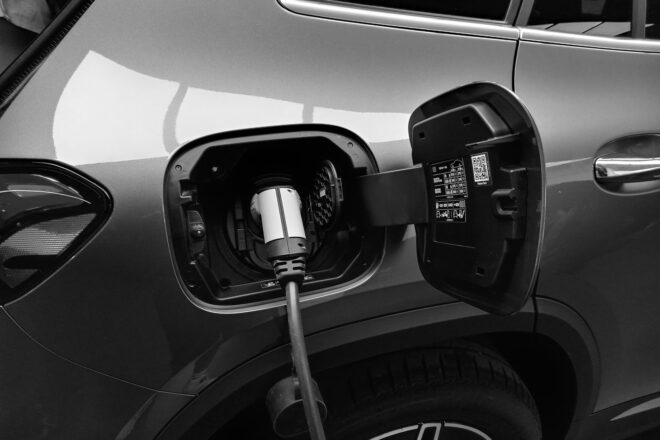 Black and white image of an EV being charged