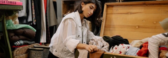 A woman sitting beside a chest of clothes
