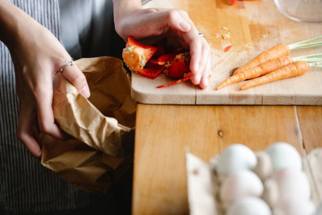 Food scraps being tossed into a paper bag