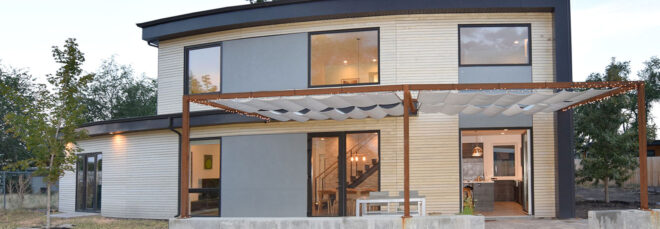 Two story passive home with a curved roof