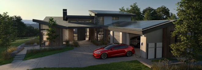 A house with a red Tesla car parked on the curb plugged into a charging port in the garage