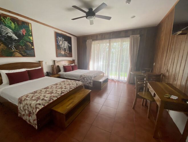 Two queen beds in a room with ceiling fan and window