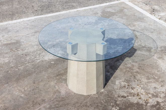 A circular glass table with a stone leg