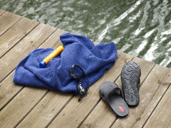 Shoes near a lake and towel