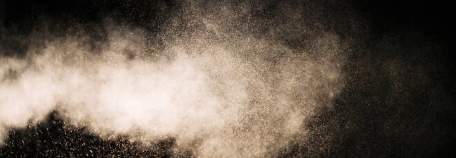 A plume of particles released against a black background