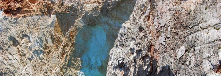 A close-up of a cliff with a crack in the middle of the photo