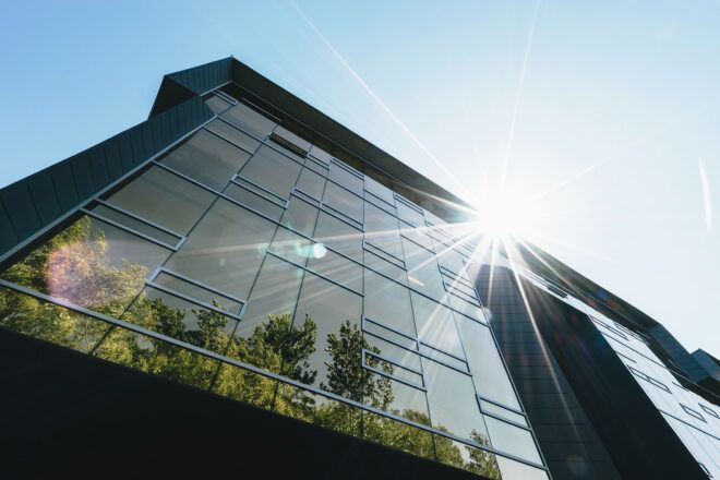 A glass building surface reflecting sunlight off of it