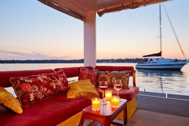 An L-shaped red sofa overlooking a view of a water bank