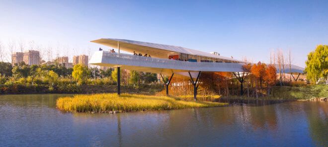A pointed white structure lifted above a wetland