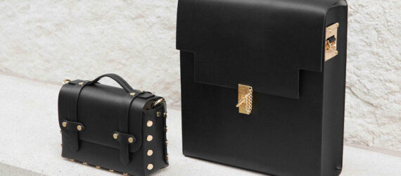 A black backpack and handbag standing on a white shelf