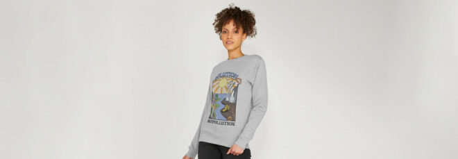 A woman with curly hair wearing a gray sweater
