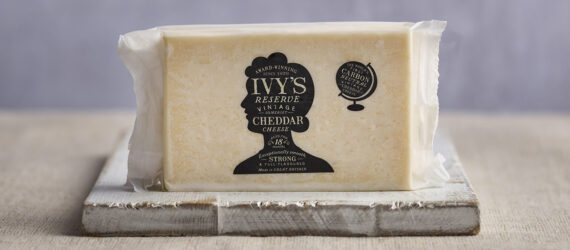 A white cheddar cheese on a wooden plate