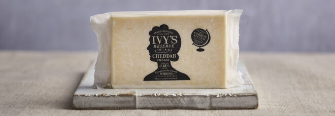 A white cheddar cheese on a wooden plate