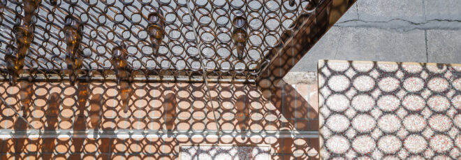 A bottle wall that leaves circular shadows on the other side