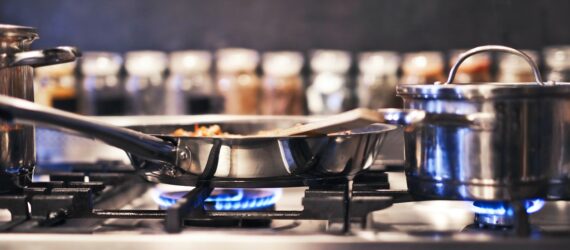 A gas stove with a pot and pan cooking on it