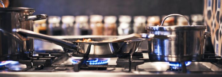A gas stove with a pot and pan cooking on it