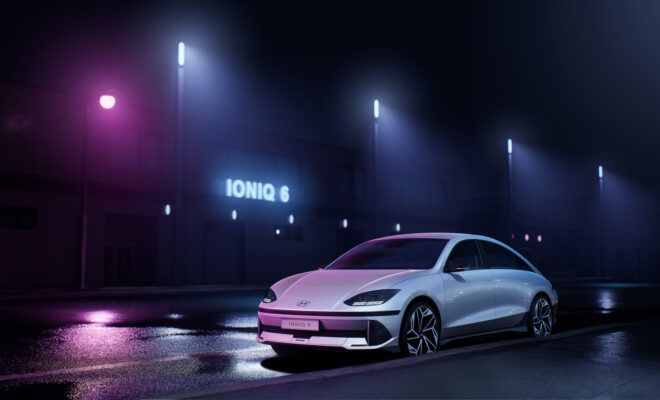 A sleek grey car under night streetlamps