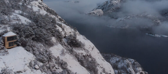 A cabin on the edge of a snowy mountain