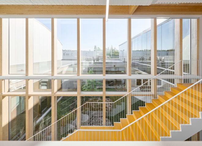 A yellow staircase that overlooks a wall of windows