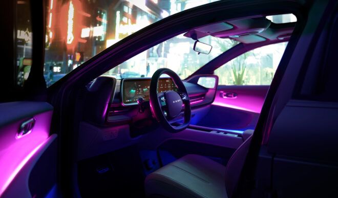 The interior steering wheel of a car has purple and blue lights