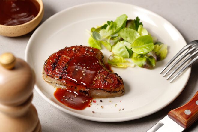 3D-printed steak on a white plate with a salad