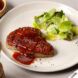 3D-printed steak on a white plate with a salad