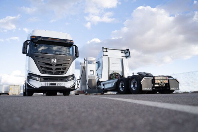 The front of a semi-truck next to the back of a semi-truck