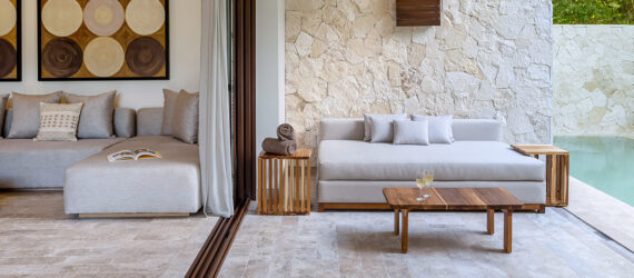 An outdoor seating area and pool separated by a glass wall
