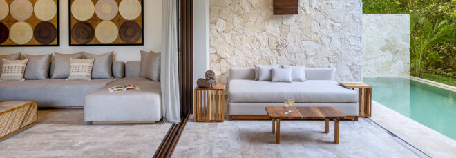 An outdoor seating area and pool separated by a glass wall