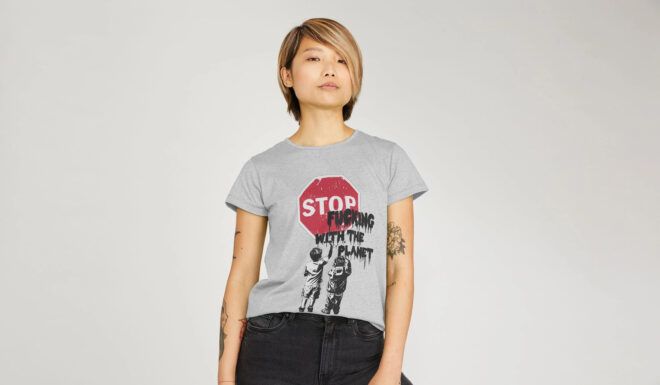 A woman with short hair parted on the side wears a gray t-shirt