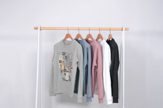 A clothesline of sweaters colors gray, blue, pink, white and black