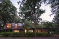A stretched out home hidden behind trees and bushes