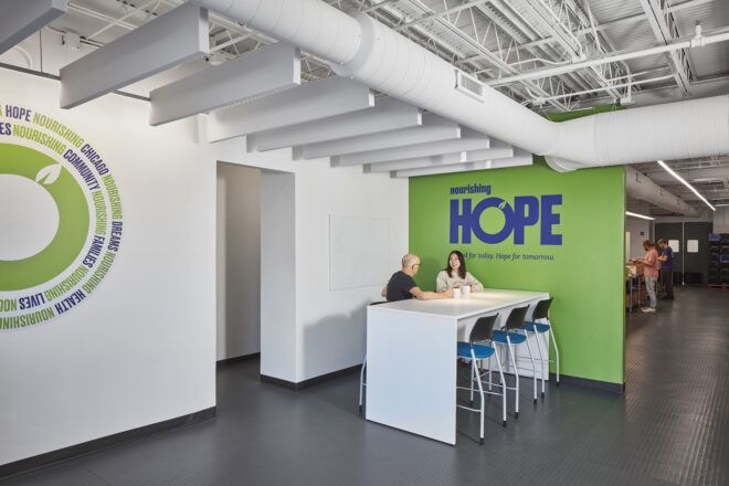 A wall that reads HOPE with a table and two people seated at the table
