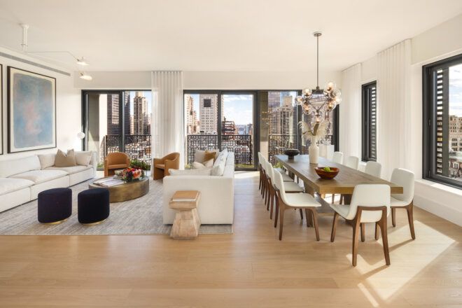 An open apartment space filled with a dining table, sofa and lounge area