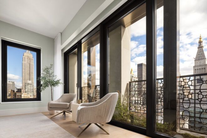 Two chairs with a coffee table makes up a seating area next to the windows