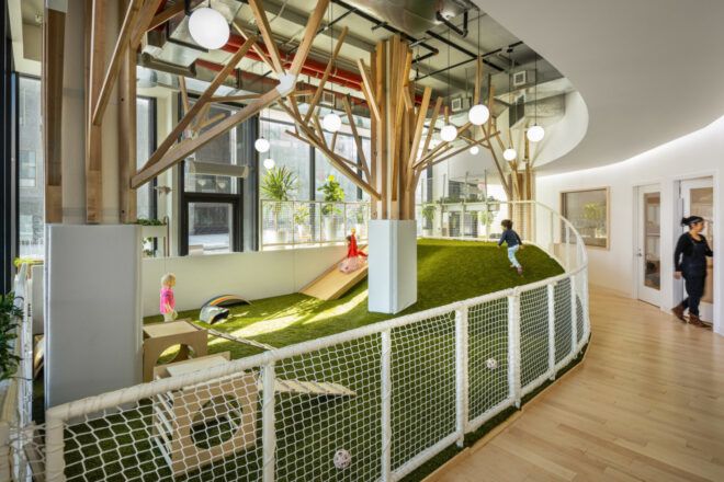 Children playing in an indoor garden space with small wooden playground equipment