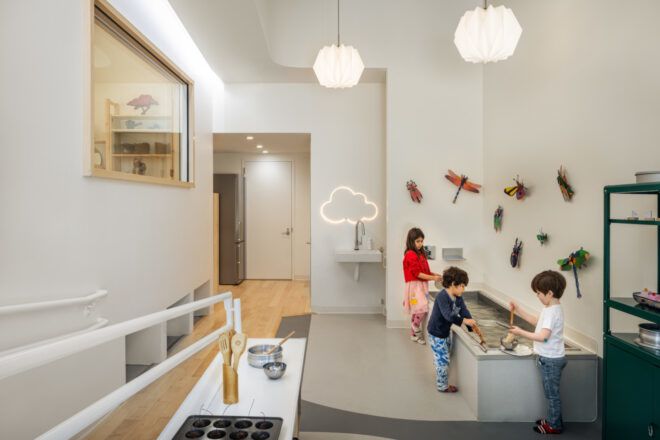 Children playing with tools at the edge of a large tub filled with water