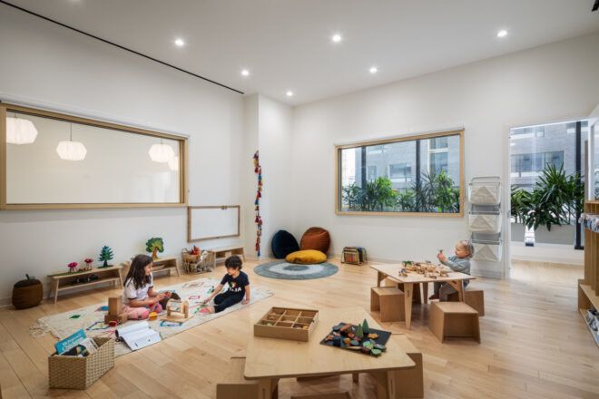 Three preschoolers seated in different spots in a classroom