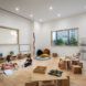Three preschoolers seated in different spots in a classroom