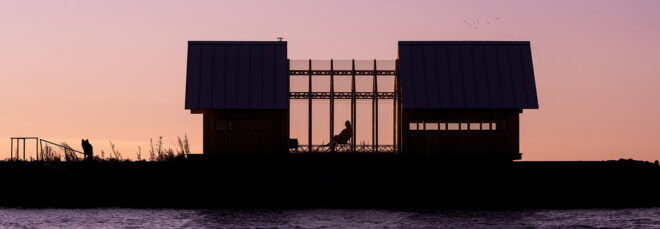 A silhouette of a home pulled open in the middle with a person sitting in a chair within