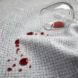 A wine glass spilled over a gray fabric