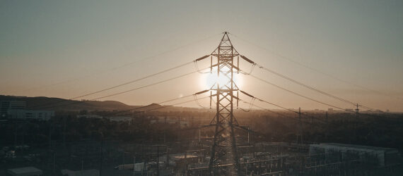 An electrical pole with wires coming out of it overlooking a sunset scenery