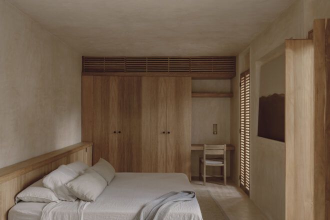 A bedroom with wooden sliding closets