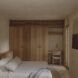 A bedroom with wooden sliding closets