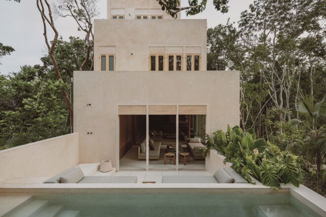 A cream colored home with a backyard pool and lounging area