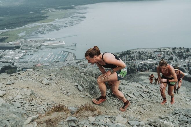 A woman in front of a line of other woman climbing a mountain