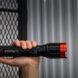 A hand holding a black flashlight